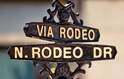 A street sign for Via Rodeo and N. Rodeo Dr.