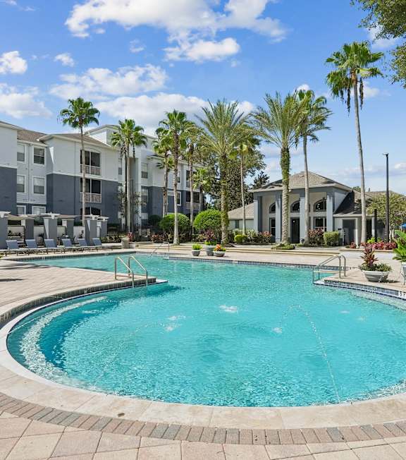 A beautiful day at the park with palm trees and a fountain.