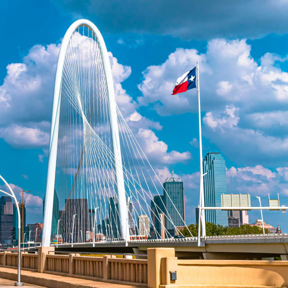 a view of a bridge with a large suspension bridge and a city with a flag at Infinity on the Mark, Texas
