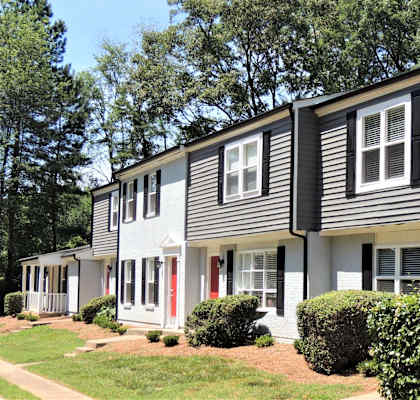 a white house with black siding and a lawn at Greenwood Village, North Carolina