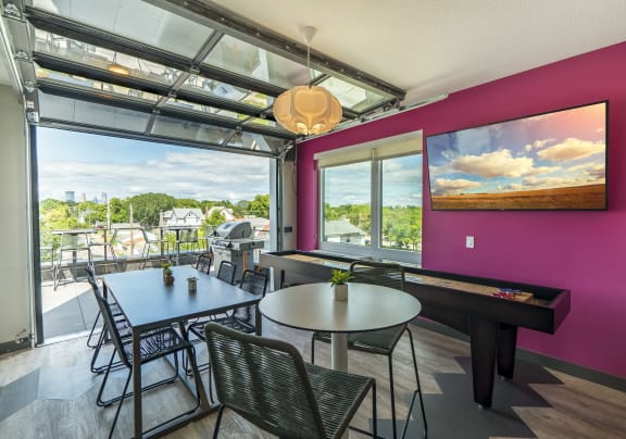 a dining area with tables and chairs and large windows