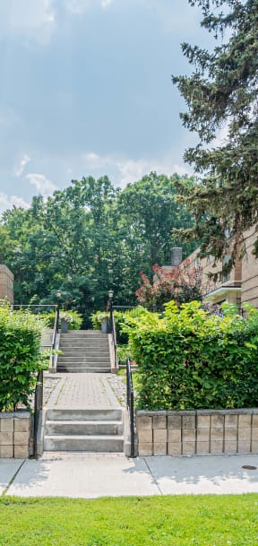 a brick building with stairs and trees in front of it