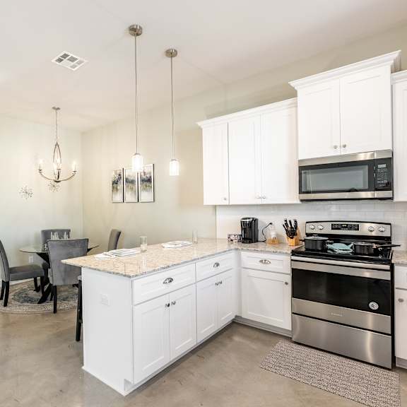 A kitchen with white cabinets and a center island.
