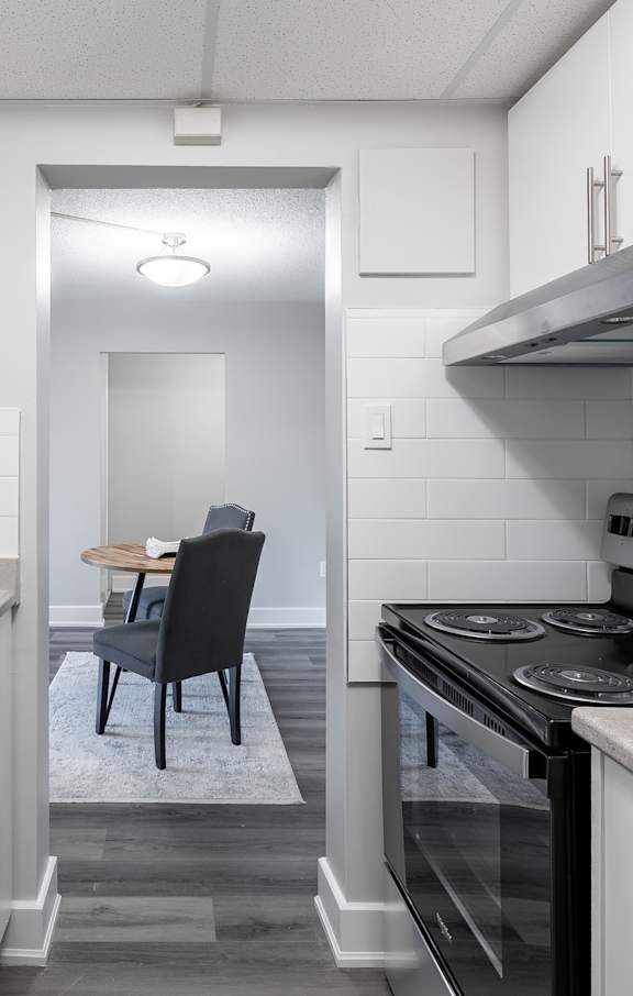 A modern kitchen with white cabinets and stainless steel appliances.