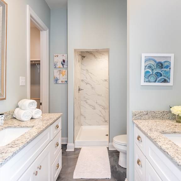 A bathroom with a marble shower and a sink.