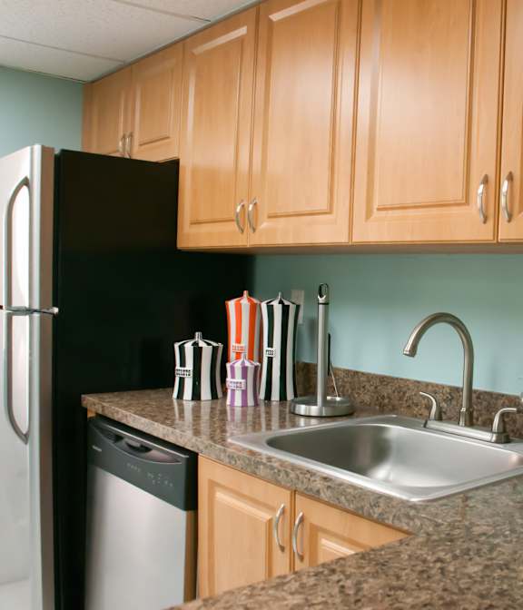 A modern kitchen with stainless steel appliances and white cabinetry.