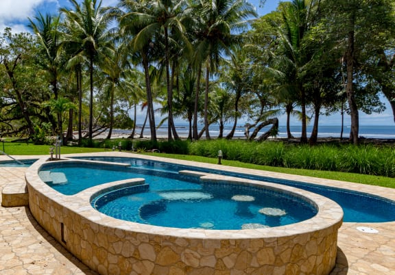 The pool at Topa Bluffs with a stone wall and trees in the background