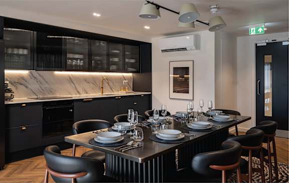 a kitchen with a long counter and bar stools