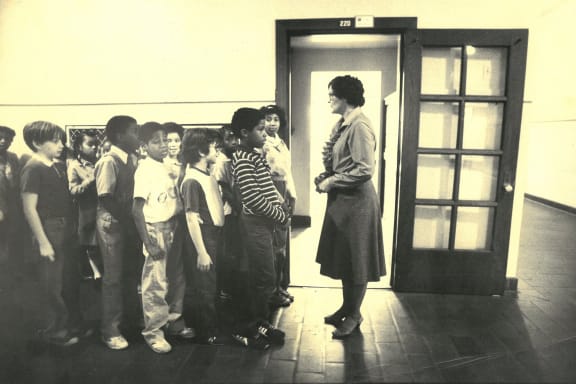 a group of children are standing in front of a door