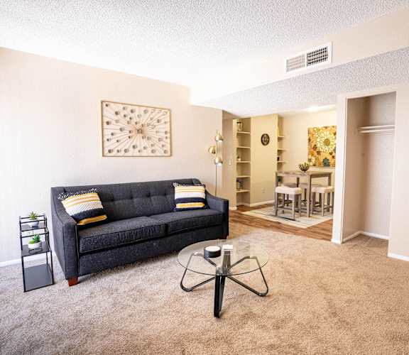 A living room with a grey couch and a coffee table.