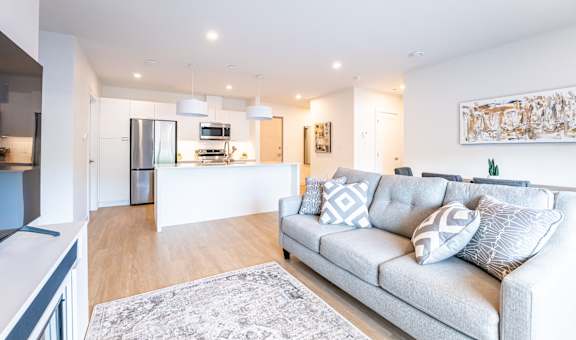 a living room with a couch and a kitchen