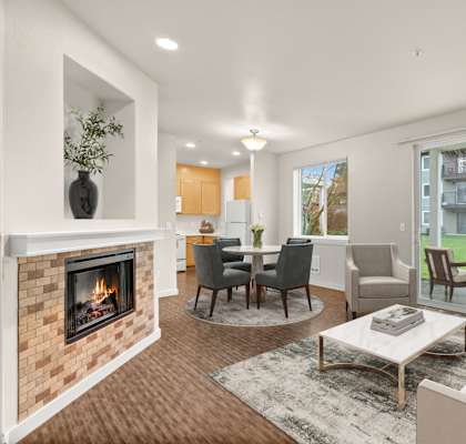 A modern living room with a fireplace and a view of the backyard.