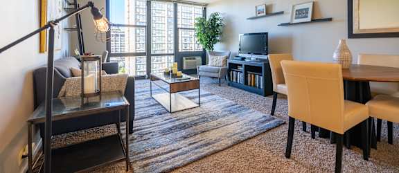 A living room with a couch, chairs, and a television.