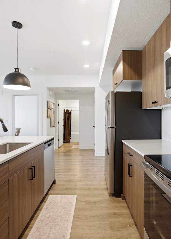 A kitchen with a white countertop and wooden cabinets.