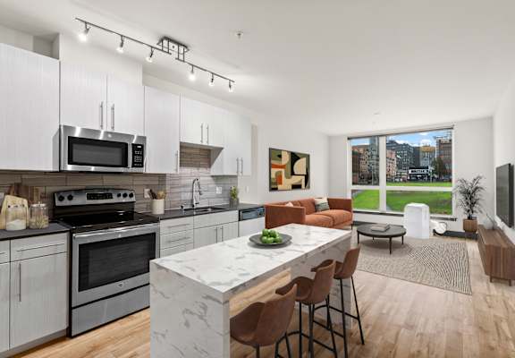 A modern kitchen with a large island and a view of the city.