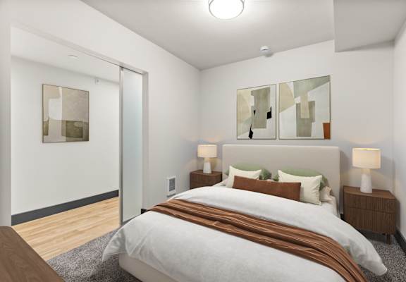 A bedroom with a large bed and two lamps.