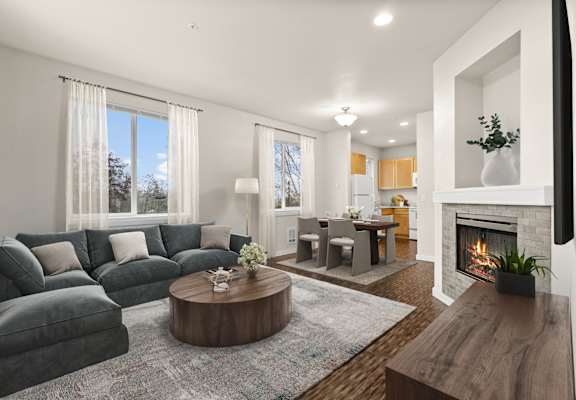 A modern living room with a grey sofa, a wooden coffee table, and a fireplace.