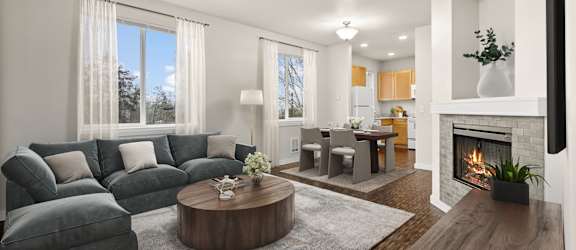 A modern living room with a grey sofa, a wooden coffee table, and a fireplace.