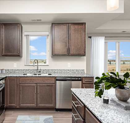 A kitchen with brown cabinets and a granite countertop.