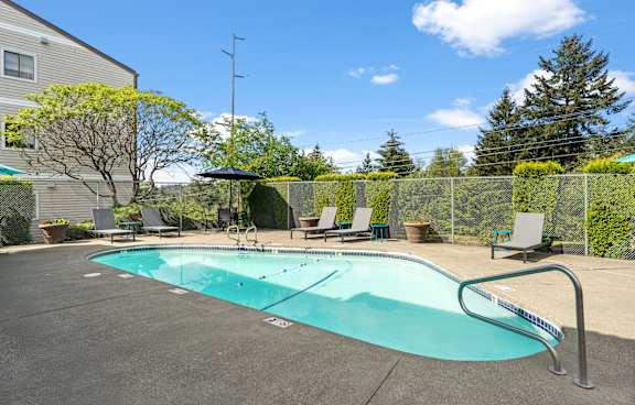 A gym with a variety of exercise equipment including treadmills, elliptical machines, and a stationary bike. at The Verandas, Tacoma, WA, 98466