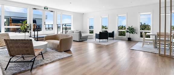 A spacious living room with wooden floors and furniture.