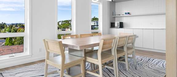 A dining room with a table and chairs.