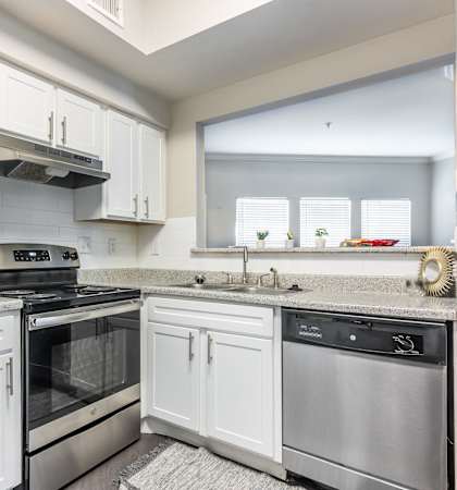 a kitchen with stainless steel appliances and white cabinets