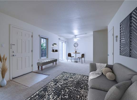 a living room and dining room with a couch and a rug
