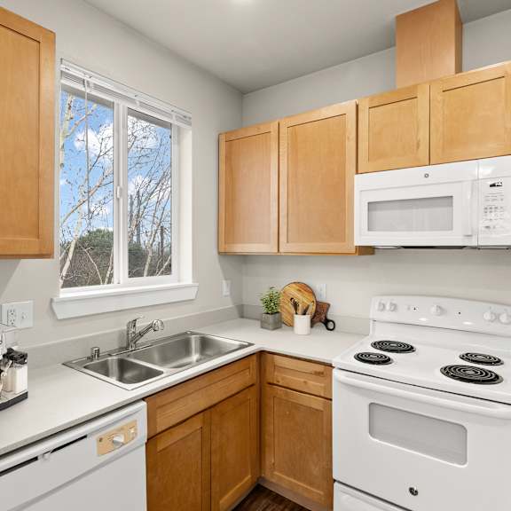 A kitchen with wooden cabinets and white appliances.