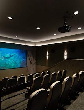A row of black chairs are set up in front of a large screen.