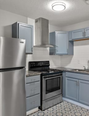 a kitchen with stainless steel appliances and blue cabinets