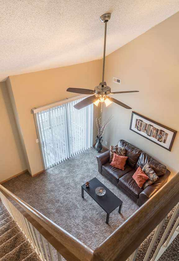 a living room with a couch and a ceiling fan