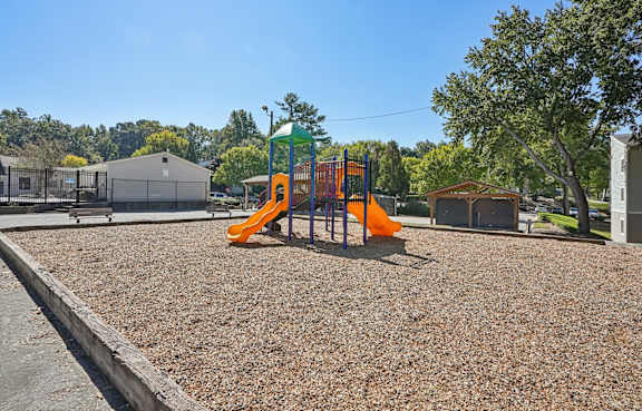 A playground with a slide and a green and white structure.