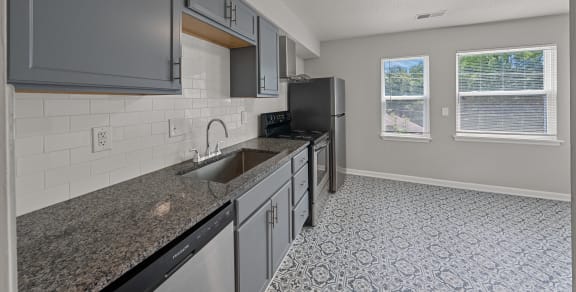 an empty kitchen with granite counter tops and a sink