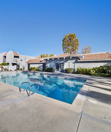 A swimming pool in a residential area with a house in the background.