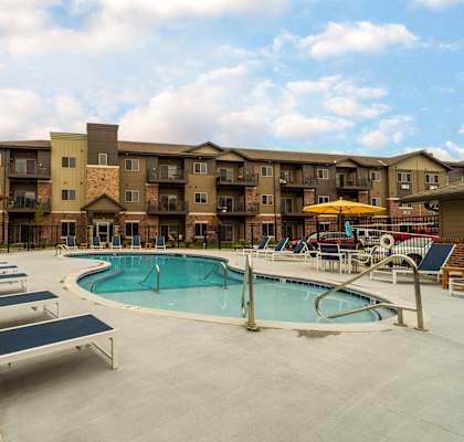 Apartment community pool with comfortable lounge chairs.