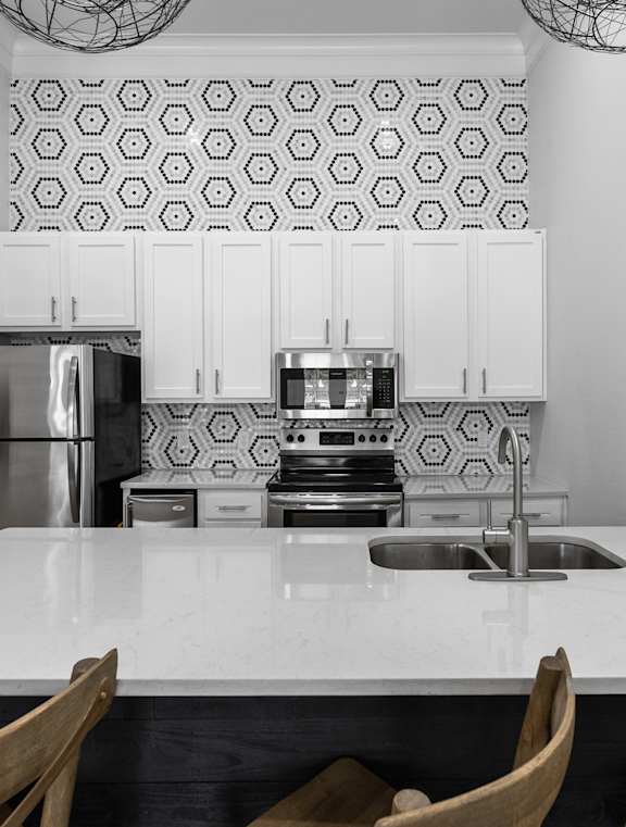 A kitchen with a refrigerator, stove, and sink.