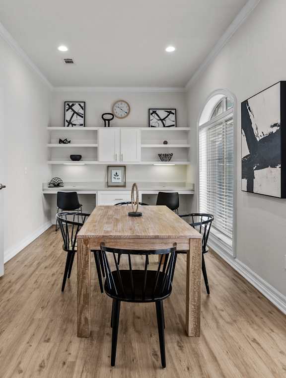 A kitchen with black appliances and white cabinets.