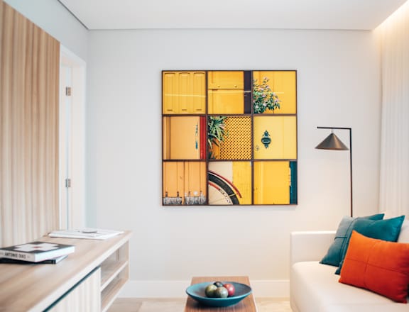 a living room with a couch and a yellow wall art