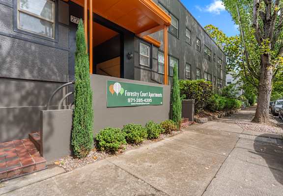 The image shows the front of a building with a sign that reads