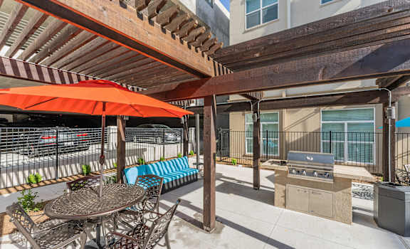 a patio with a table and chairs and a grill at Residences at 3000 Bardin Road, Texas, 75052