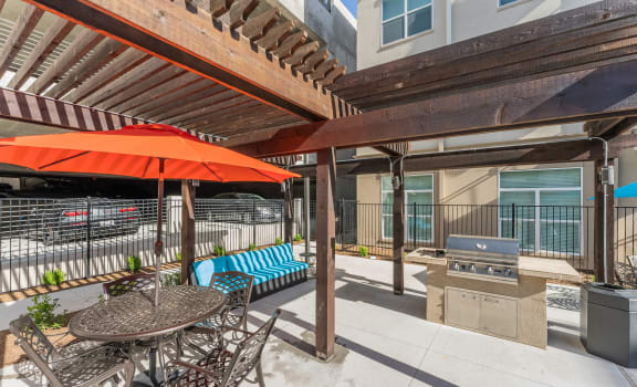 a patio with a table and chairs and a grill at Residences at 3000 Bardin Road, Texas, 75052