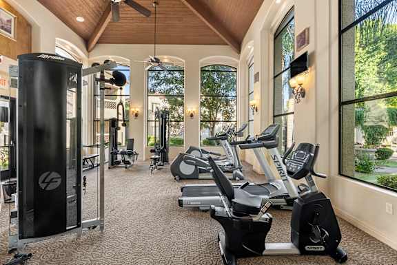 A gym with treadmills, elliptical machines, and other exercise equipment.