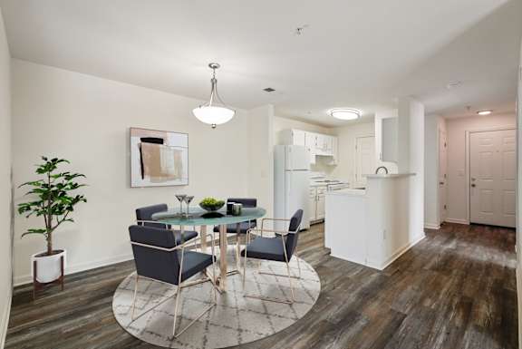 A modern dining room with a glass table and chairs.