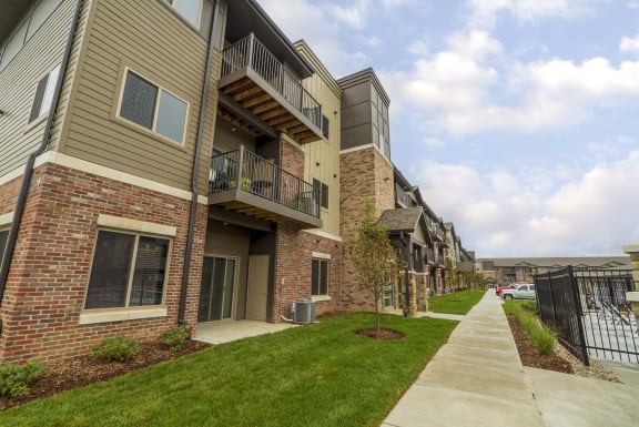 an exterior view of an apartment building with a sidewalk