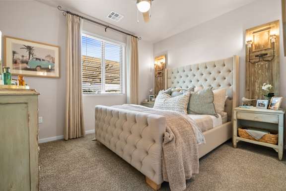 A bedroom with a large bed and a painting of a car on the wall.