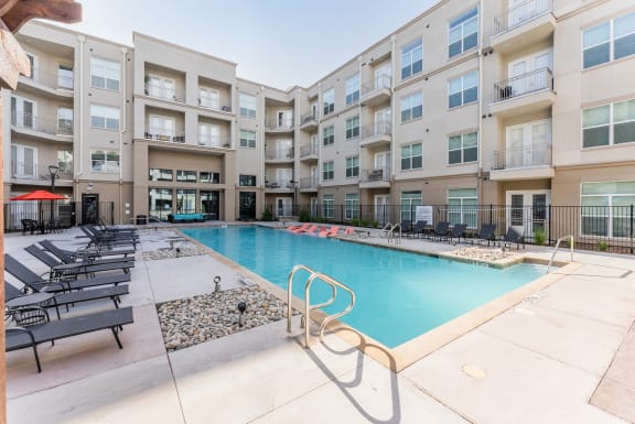 Swimming Pool Area With Shaded Chairs at Residences at 3000 Bardin Road, Grand Prairie, 75052