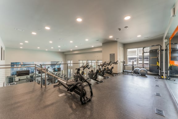 a spacious fitness center with cardio machines and weights at Residences at 3000 Bardin Road, Grand Prairie, 75052