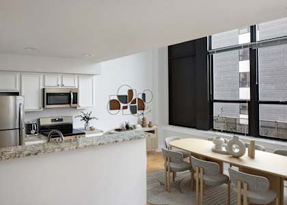 a kitchen and dining area with a table and chairs and a refrigerator