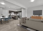 Thumbnail 4 of 4 - A modern living room with a grey couch and a television.